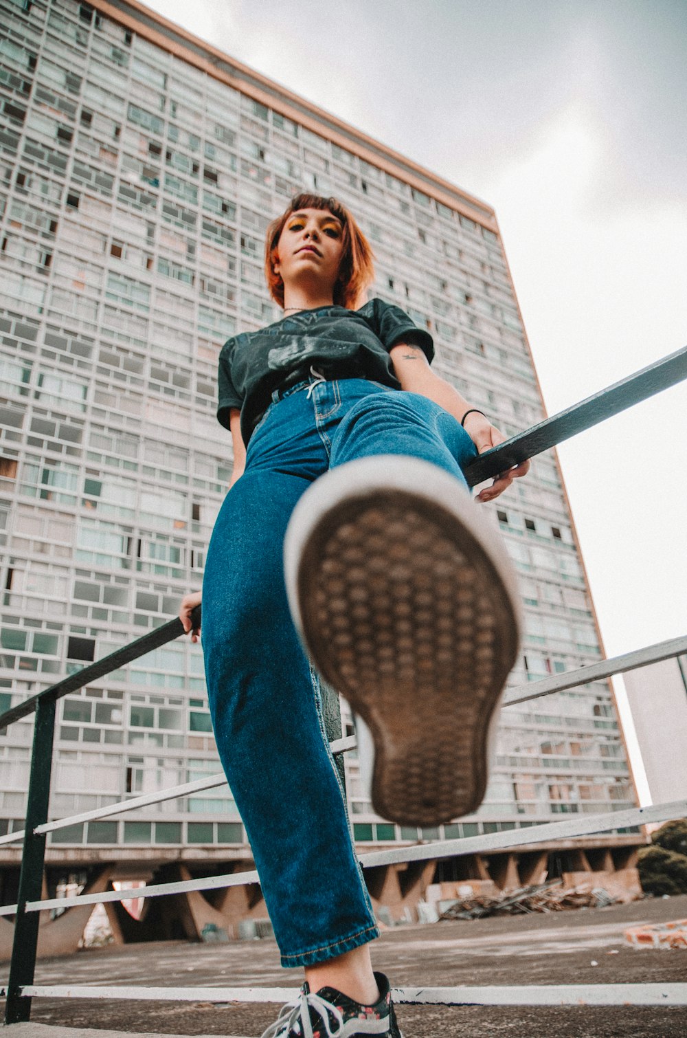 low angle view of woman sits on rail