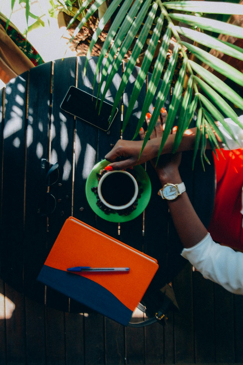 person holding white coffee cup on table