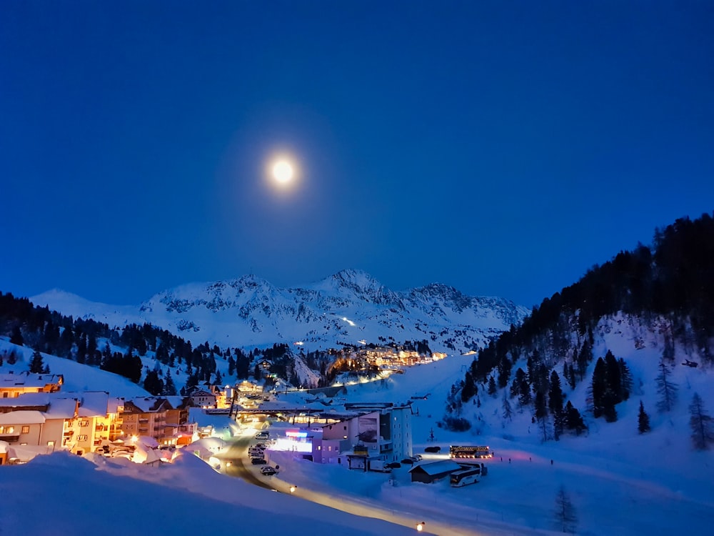 Bâtiments et maisons éclairés avec champ enneigé pendant la nuit