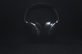 A pair of high-quality headphones resting on a neon-lit table.