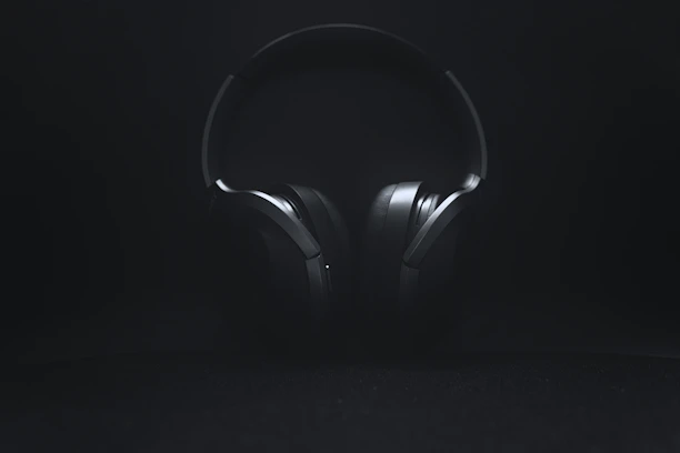 Modern wireless headphones resting on a minimalist white surface with soft natural light