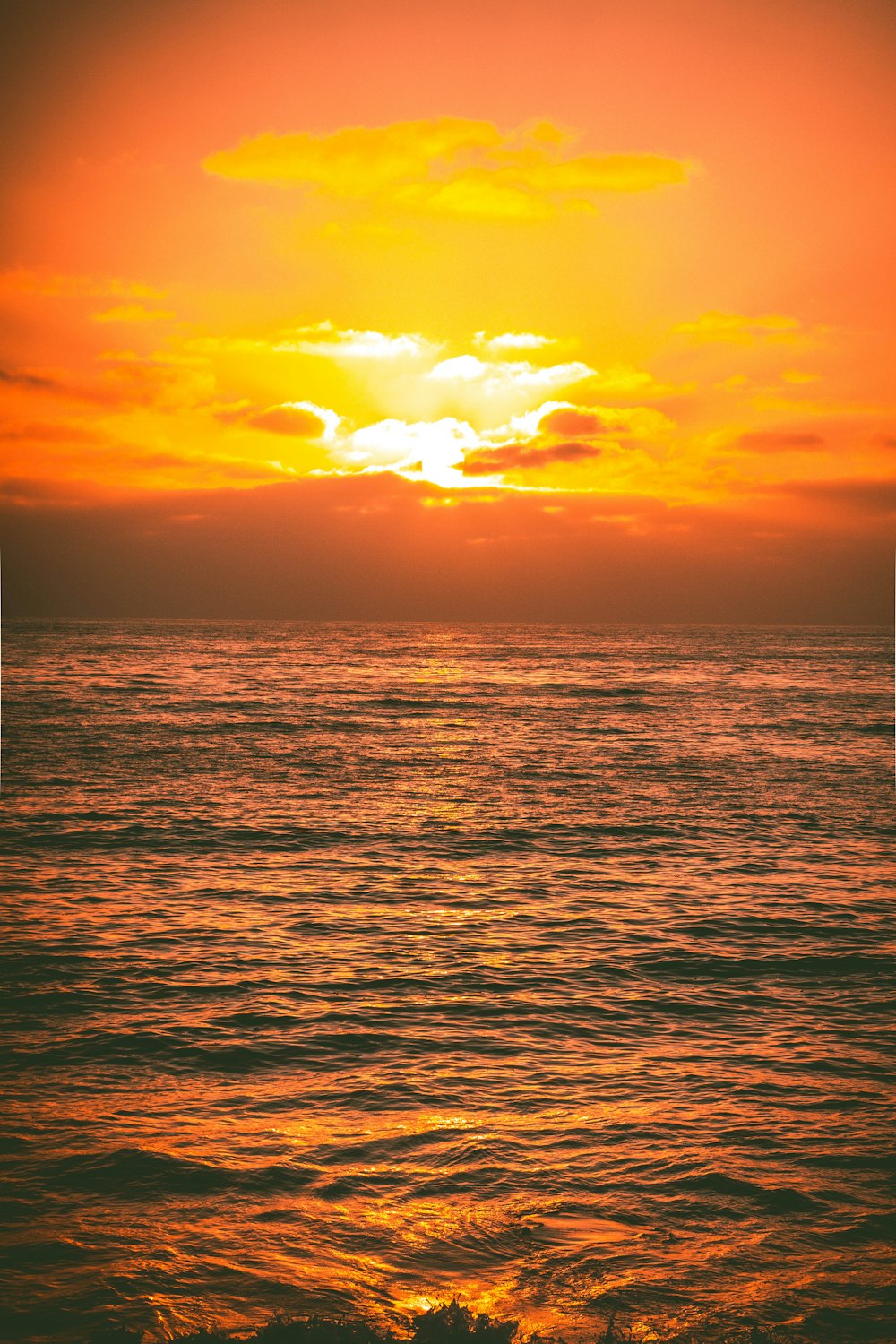 sea under white cloudy sky during sunset