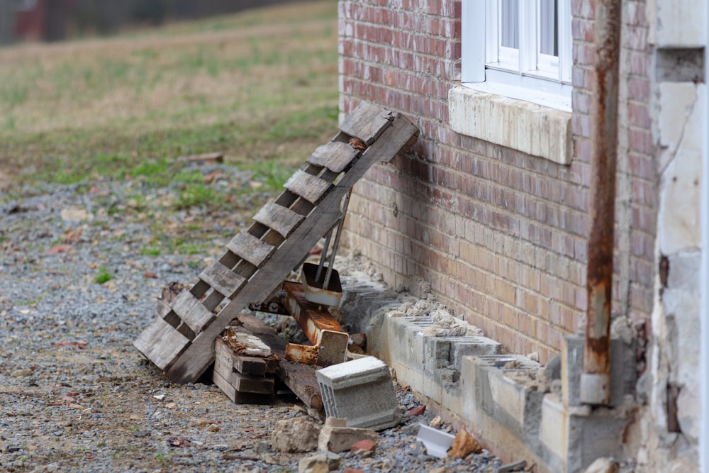 brown wooden ladder beside brick wall