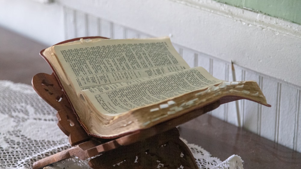 opened Bible on brown wooden stand
