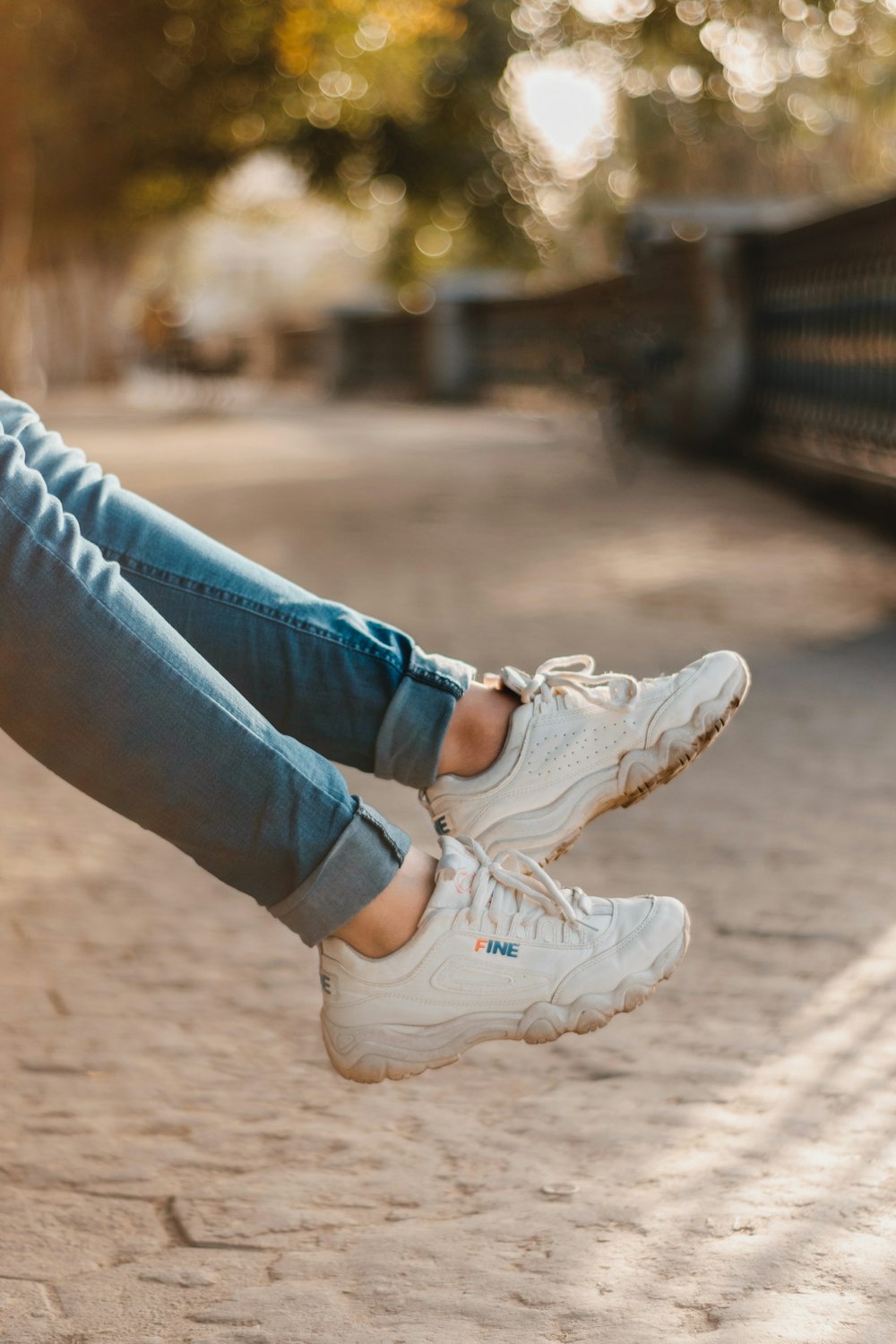Person wearing denim jeans and white Fila sneakers photo – Free Grey Image  on Unsplash