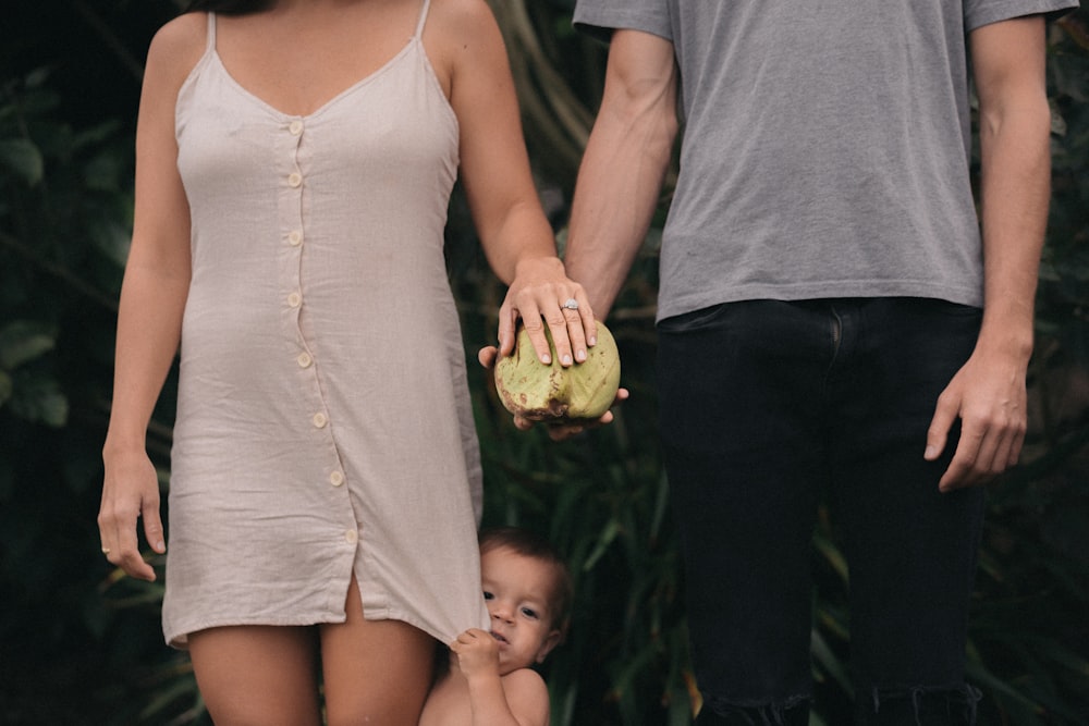 toddler between woman and man standing