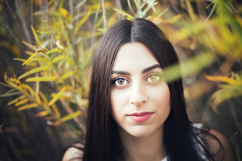 woman with long black hair in front of green grass