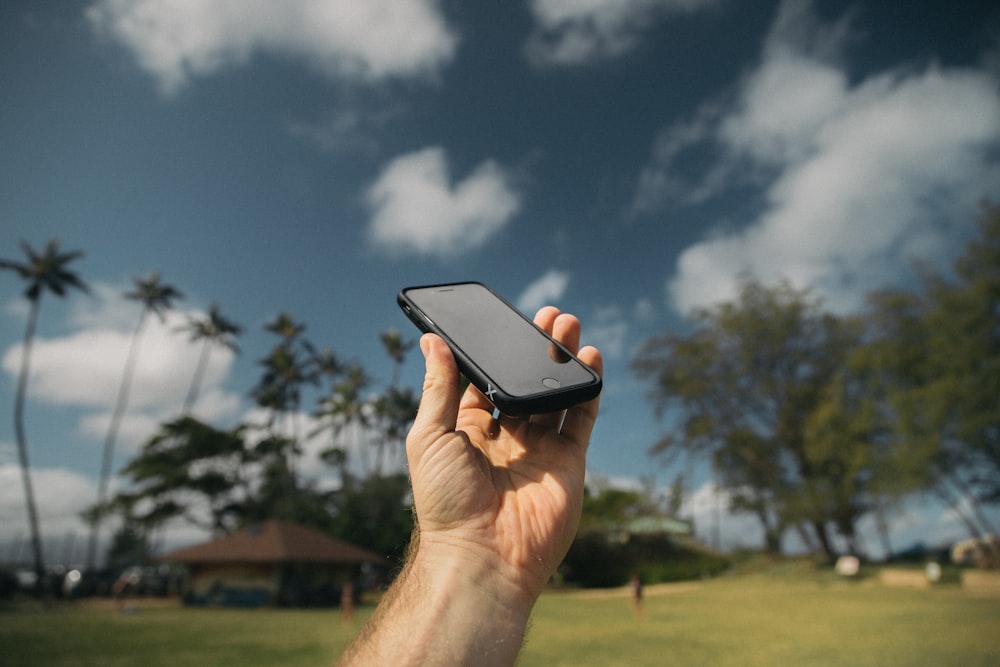 person holding black iPhone during daytime