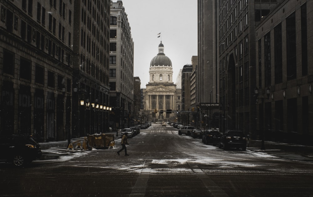 person walking on street between buildings