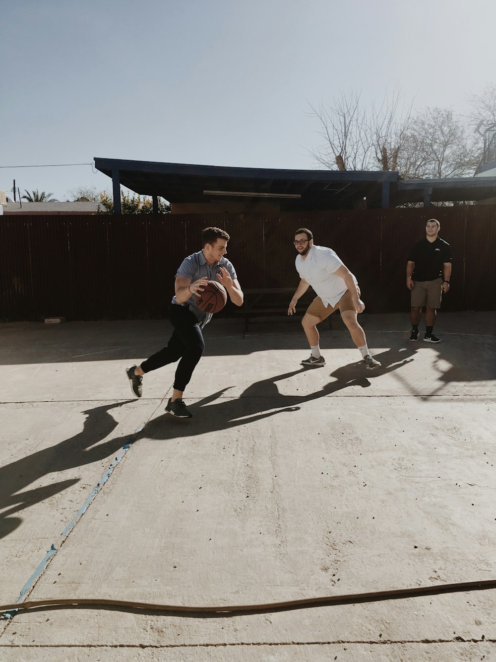 three men playing basketball