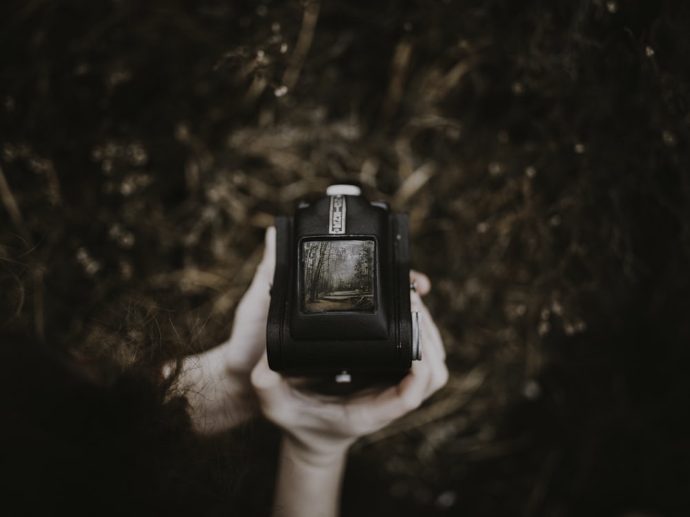 person holding black vintage device