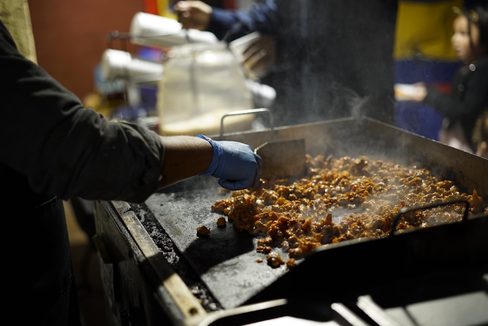 person cooking on electric griddle