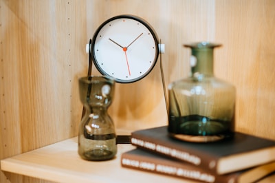 A modern desk clock with a sleek, minimalist design on a table.