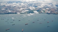 An aerial view of a logistics hub with trucks and ships.