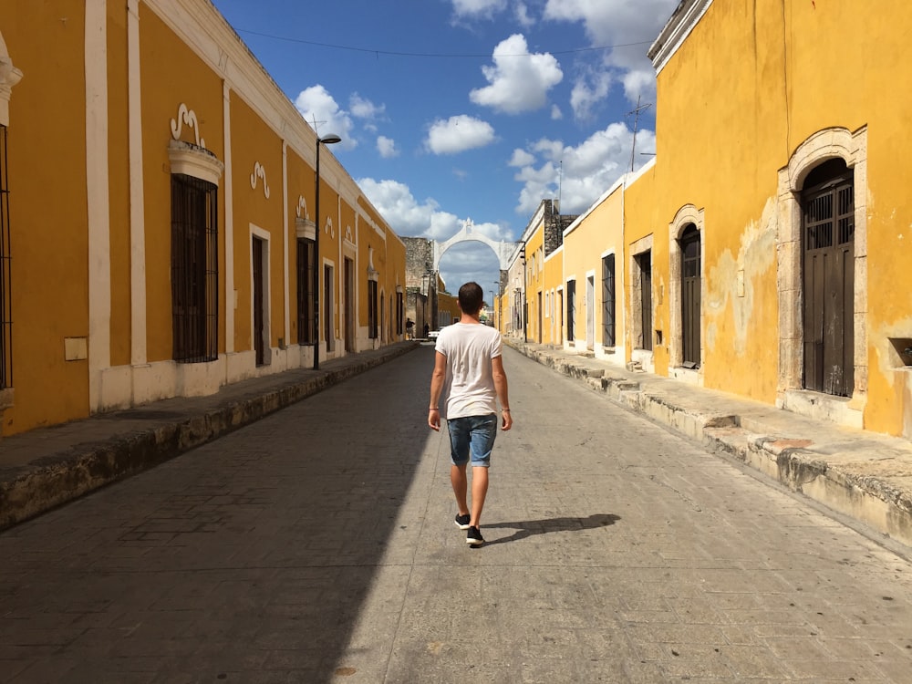 hombre caminando por un camino de hormigón gris