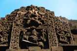 Intricate carvings of the Yungang Grottoes, the stone Buddhas watching serenely against a blue sky.