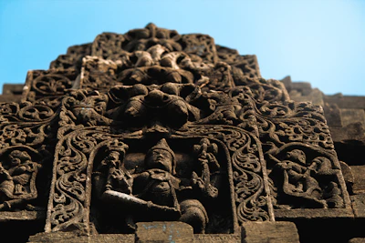 Intricate carvings of the Yungang Grottoes, the stone Buddhas watching serenely against a blue sky.