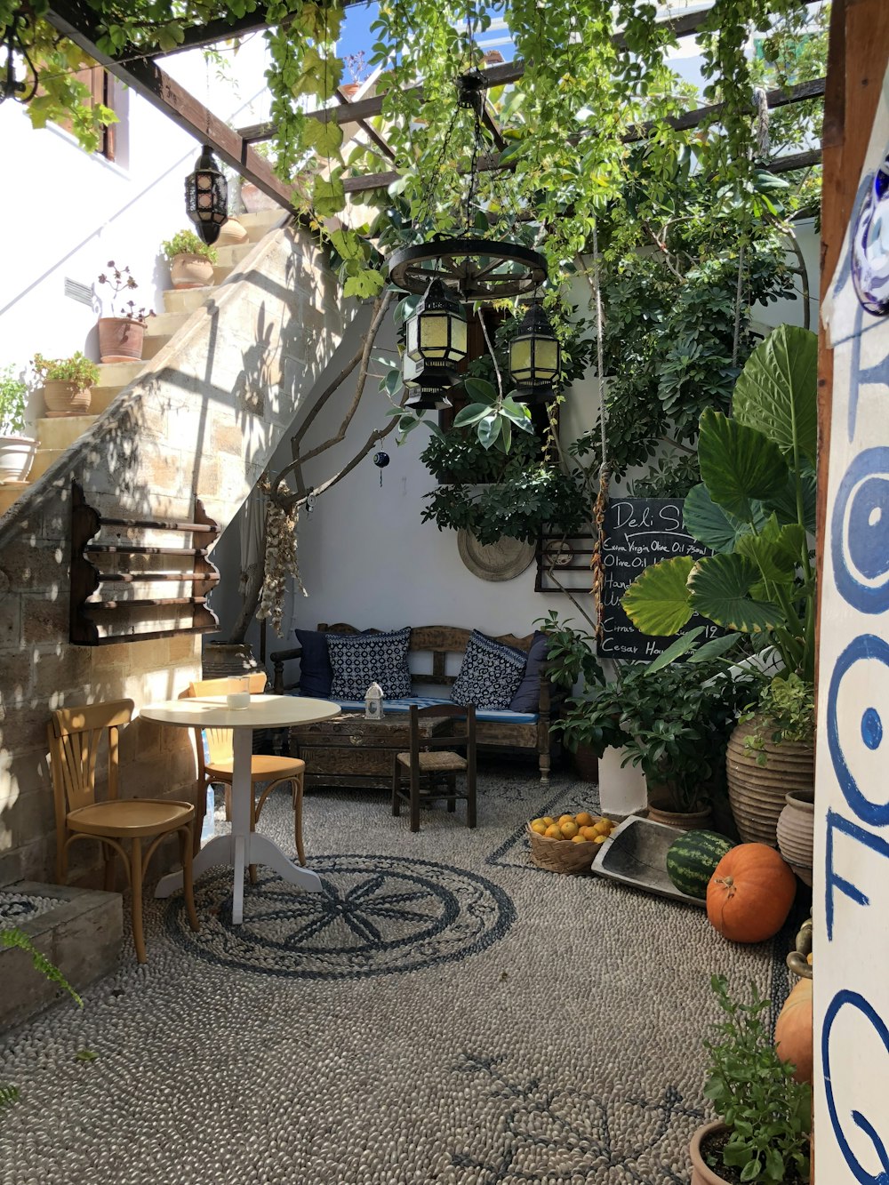 a patio with a table, chairs, and potted plants