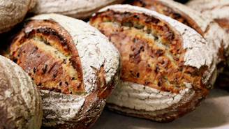 Close-up of artisanal bread loaves with a golden crust, stacked invitingly.