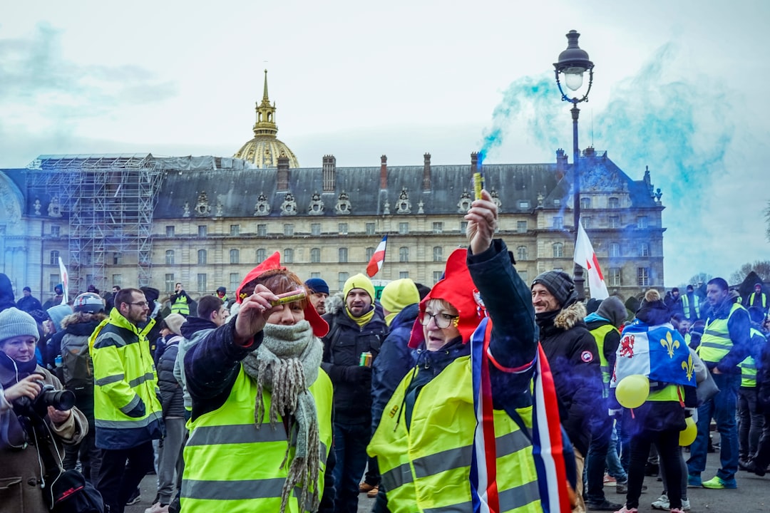 people wearing reflective vests and holding blue flares during daytime