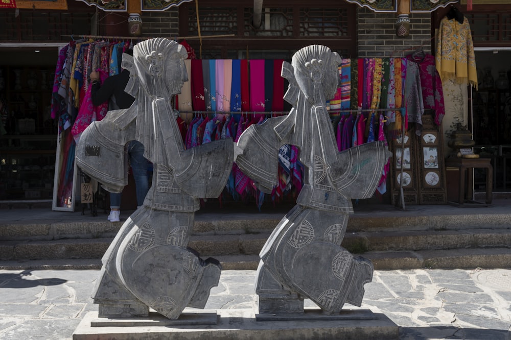 two gray concrete statues during daytie