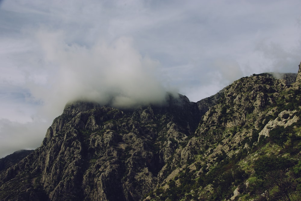 Photographie en plongée d’une montagne sous des nuages blancs