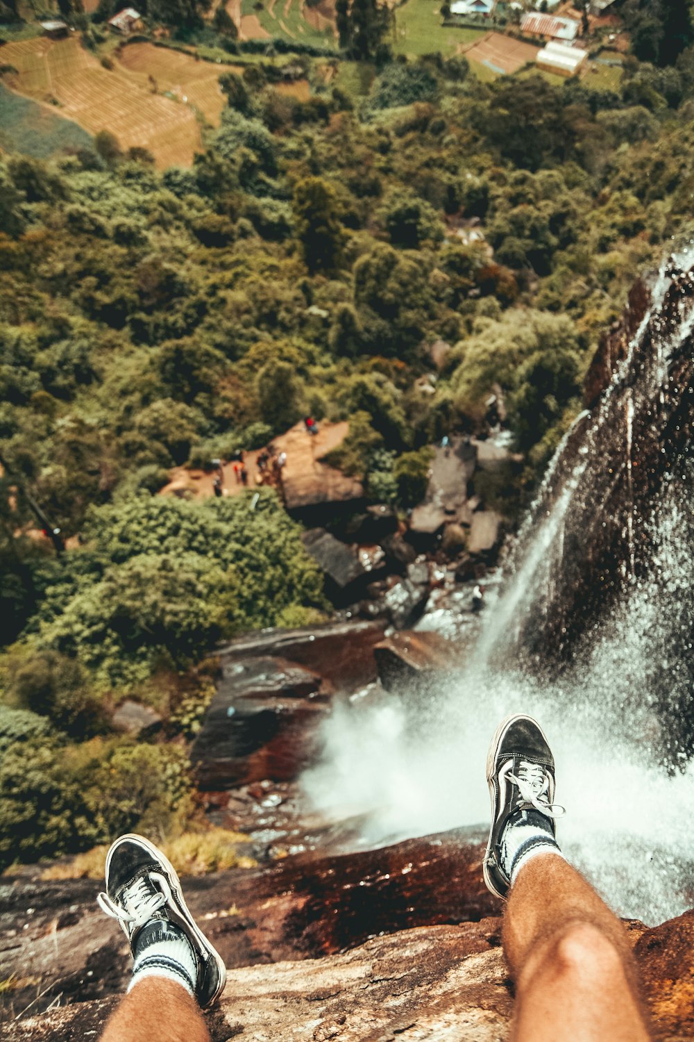 man sitting on edge of waterfalls