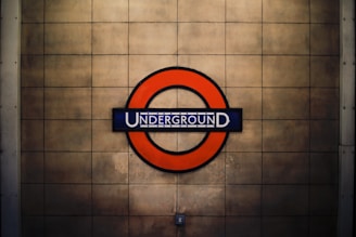 A circular red sign surrounds a blue bar with the word 'UNDERGROUND' in white, set against a beige tiled background.