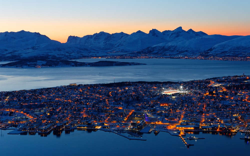 aerial photo of city buildings near snow covered mountain