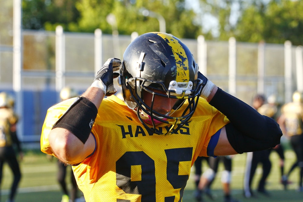 shallow focus photo of man wearing yellow Hawks 95 football jersey