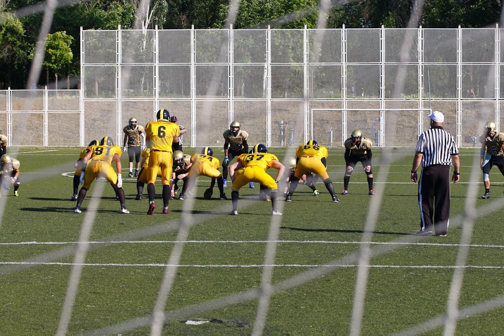 football game on outdoor green field during daytime