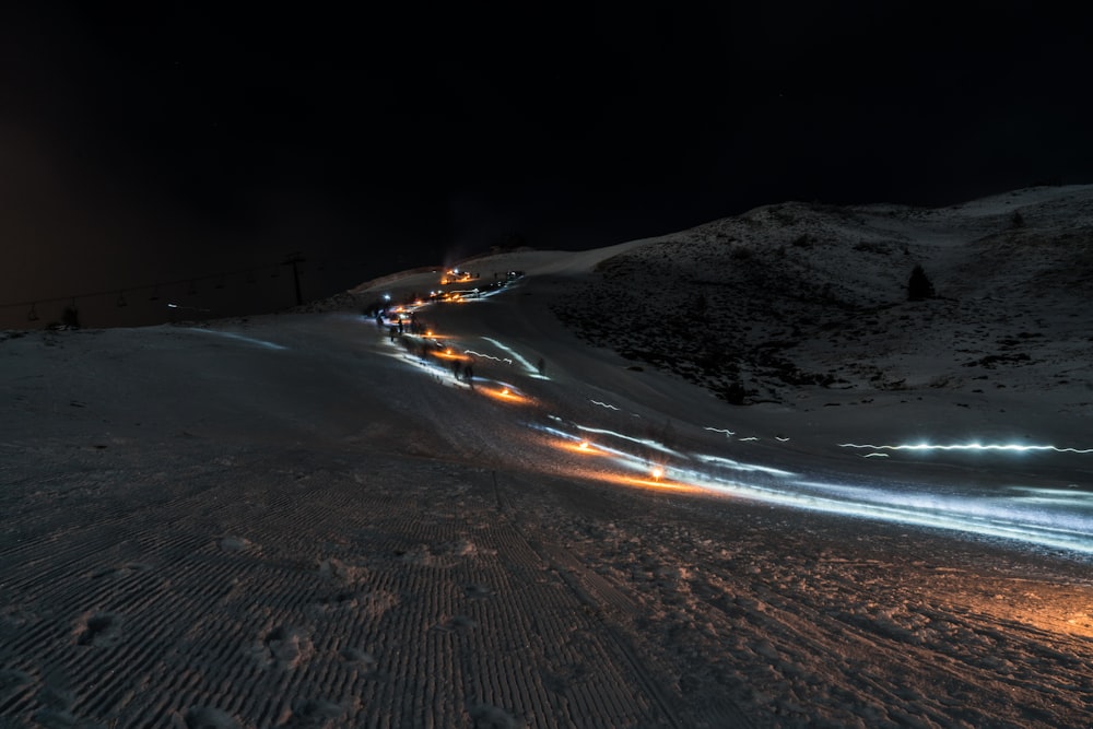 a long line of cars driving down a snow covered road