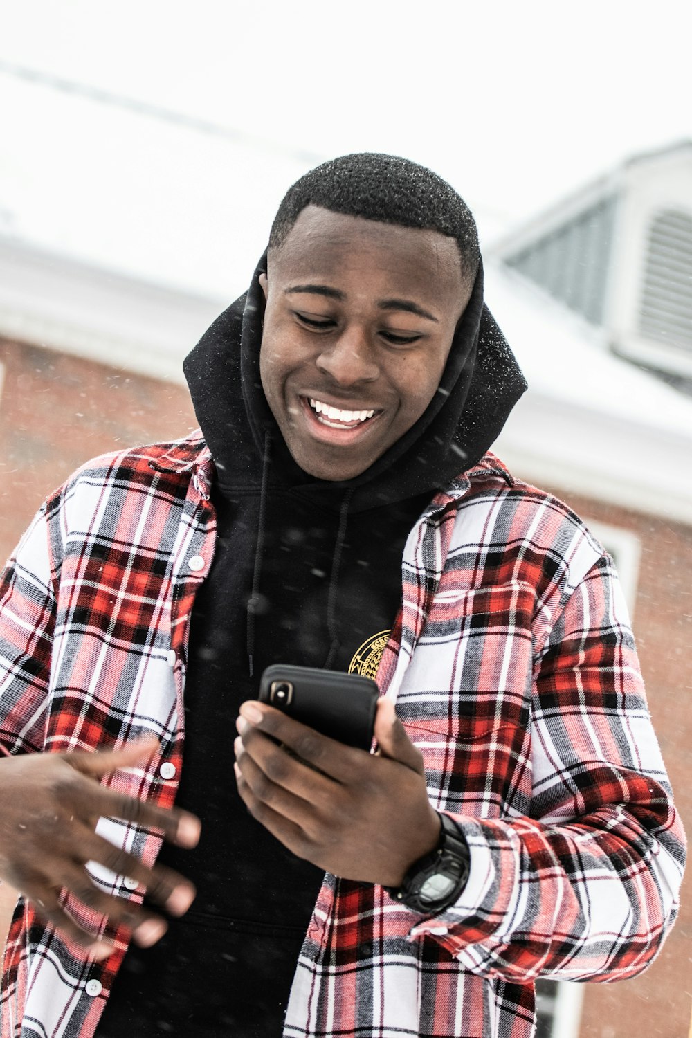 homem sorridente em pé enquanto usa o telefone