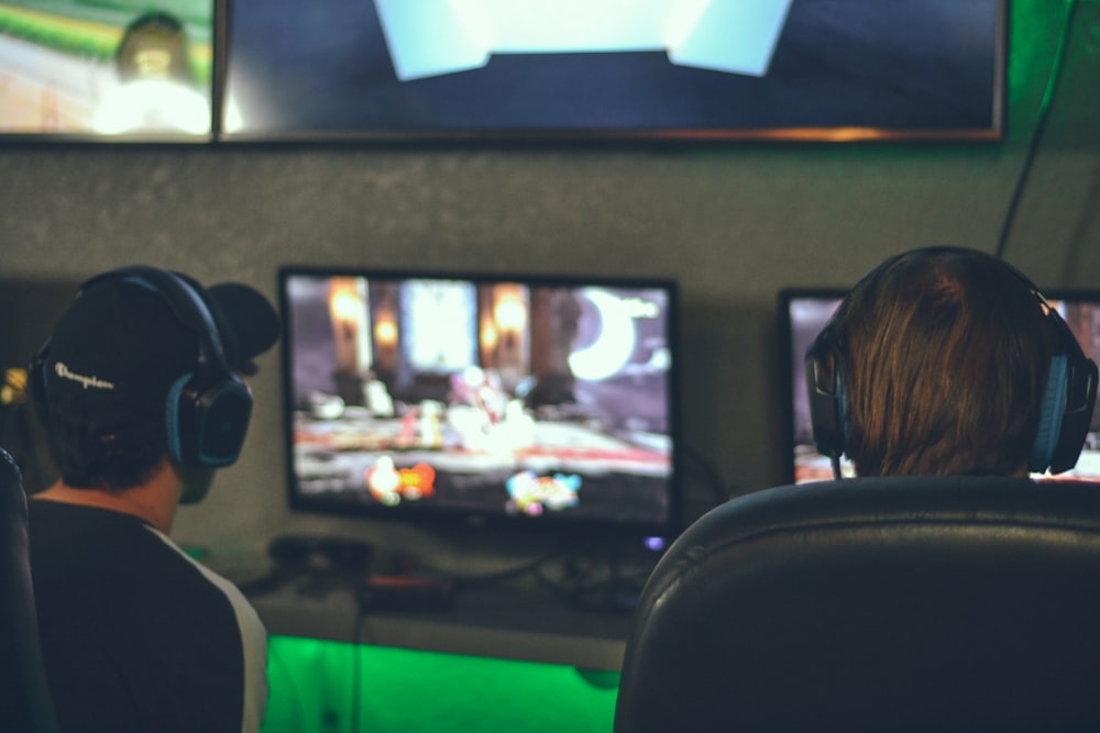 Fotografia de foco seletivo de duas pessoas jogando na frente de monitores