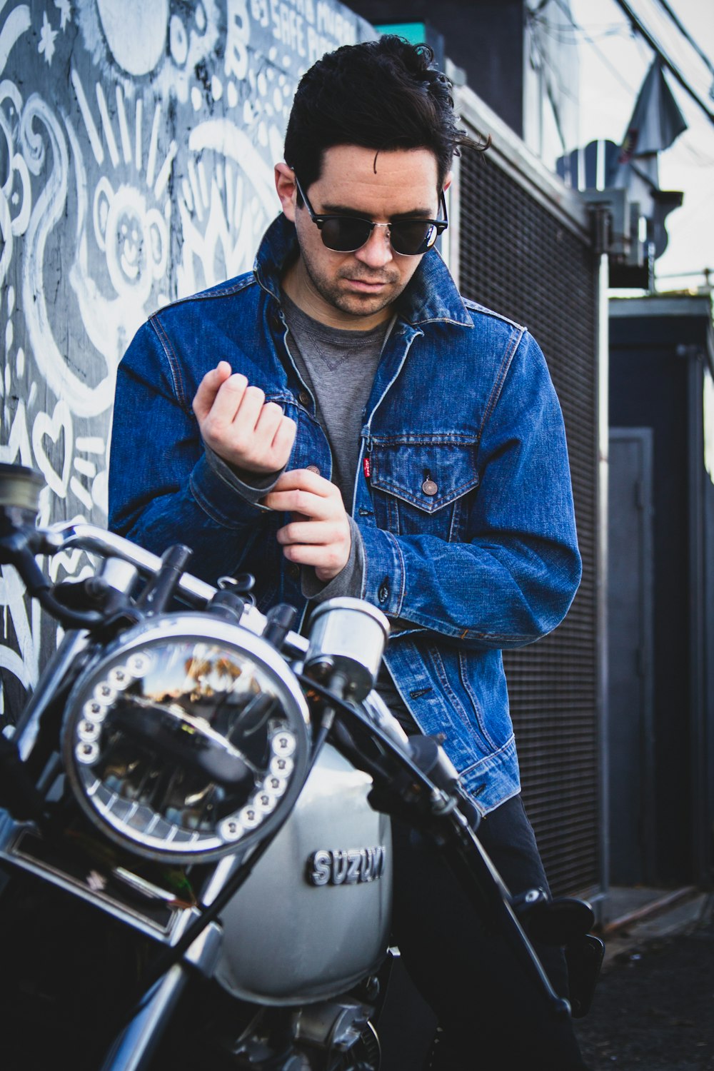 man riding on gray Suzuki motorcycle