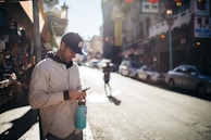 A person using a smartphone on a city street with visible WiFi hotspots nearby