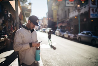 A person using a smartphone on a city street with visible WiFi hotspots nearby