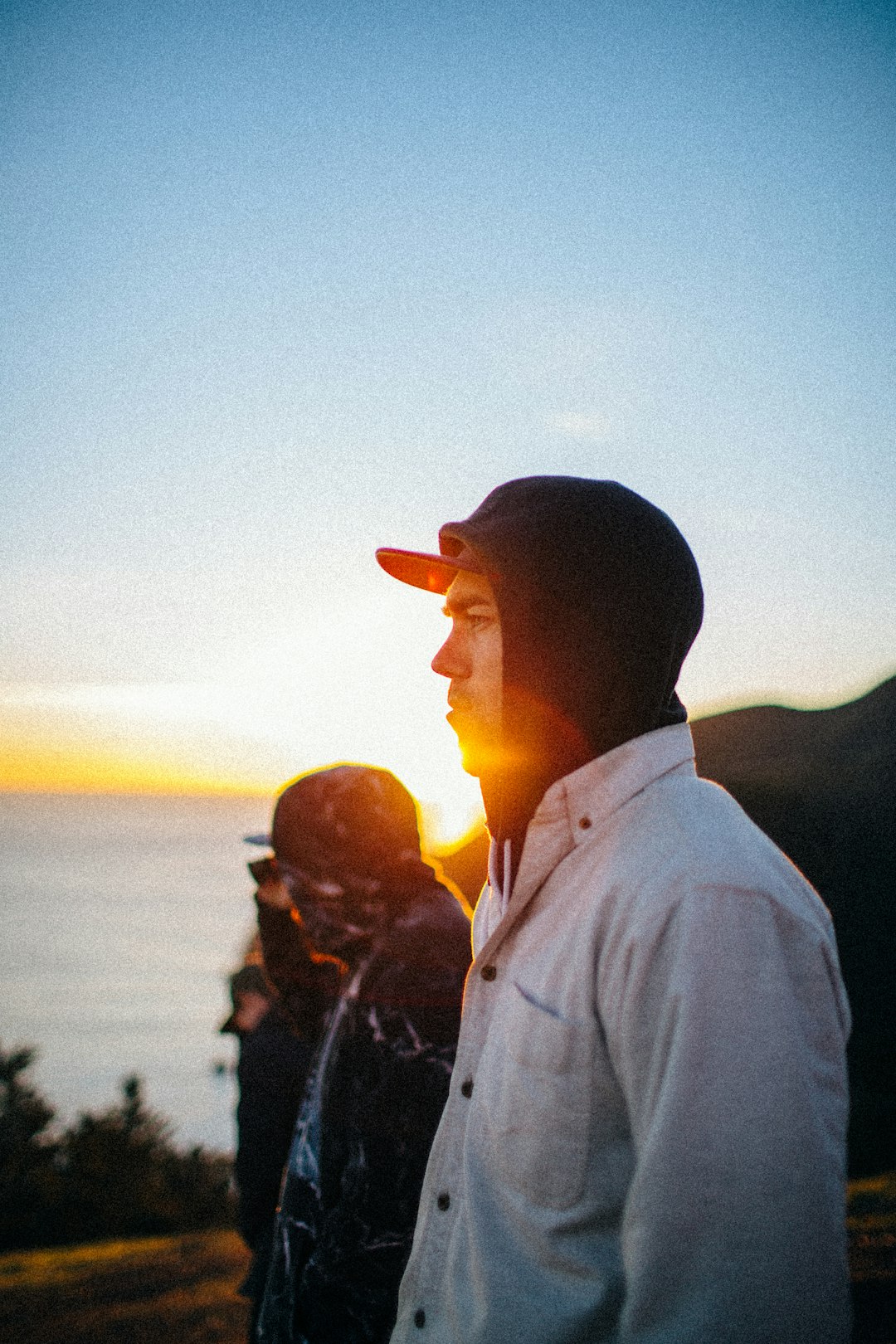 man in white dress shirt standing next to man during sunset