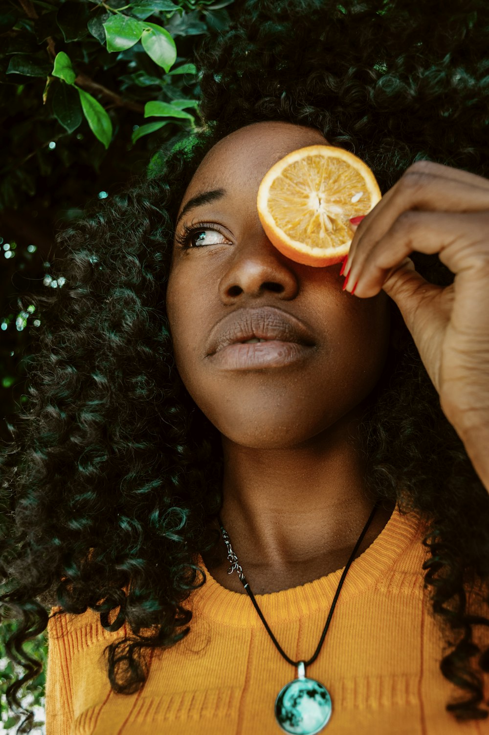 woman putting sliced lime on left eye