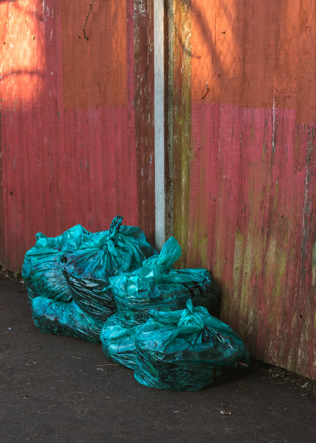 green plastic bags near wooden wall
