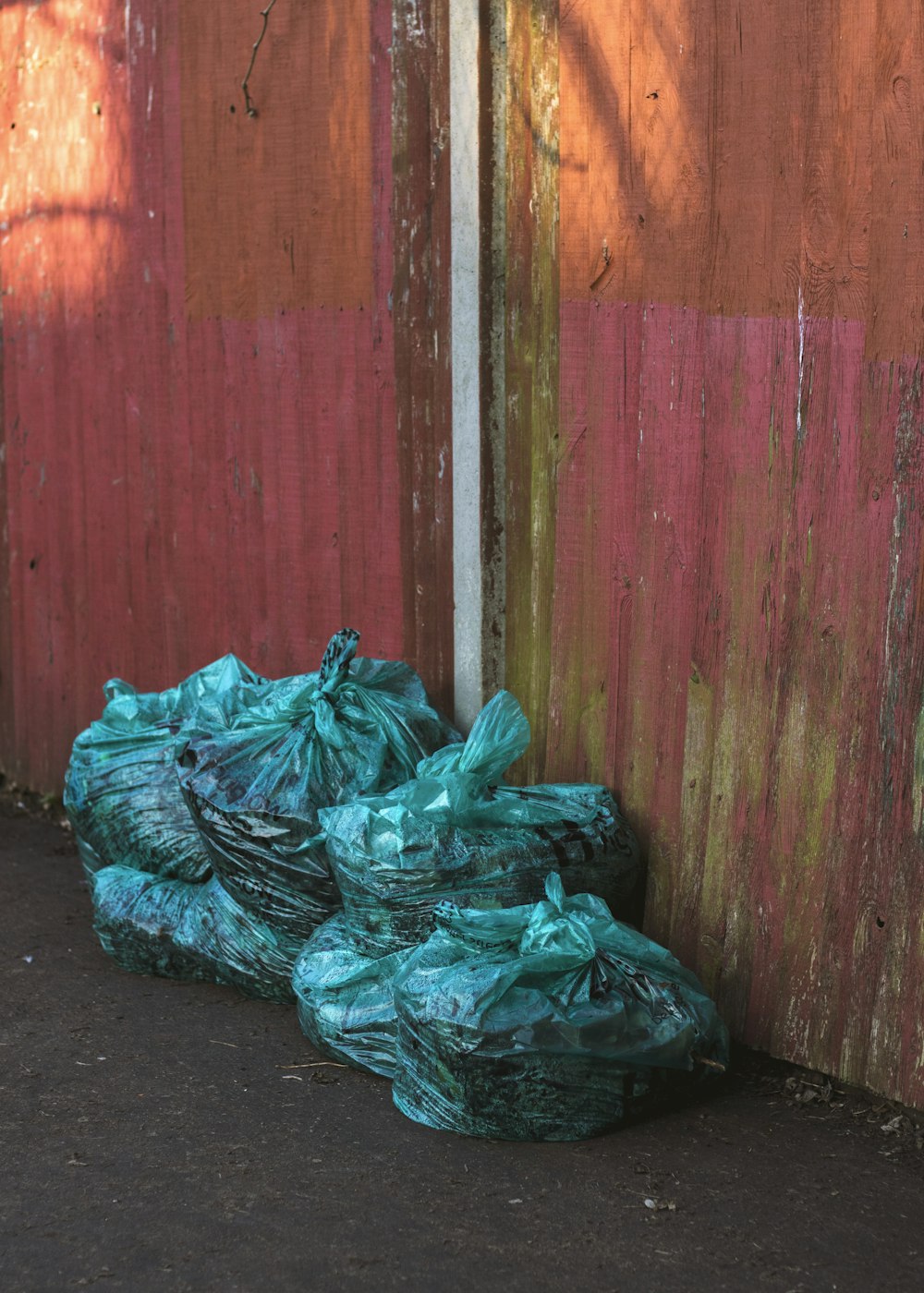 green plastic bags near wooden wall