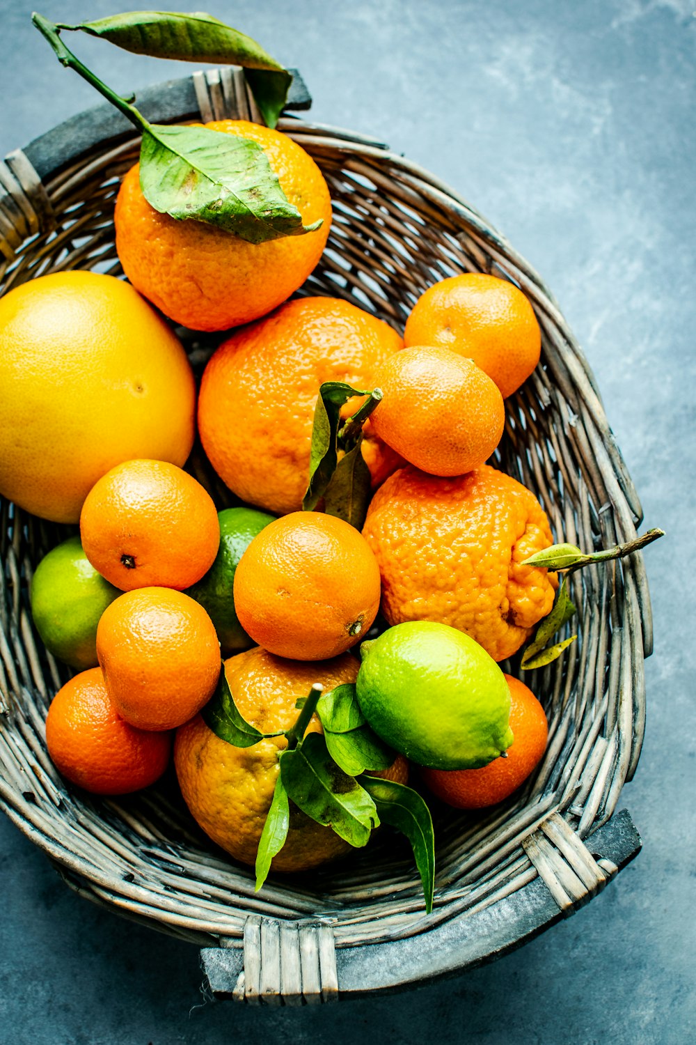 Orangen- und Zitronenfrüchte auf grauem Weidenkorb