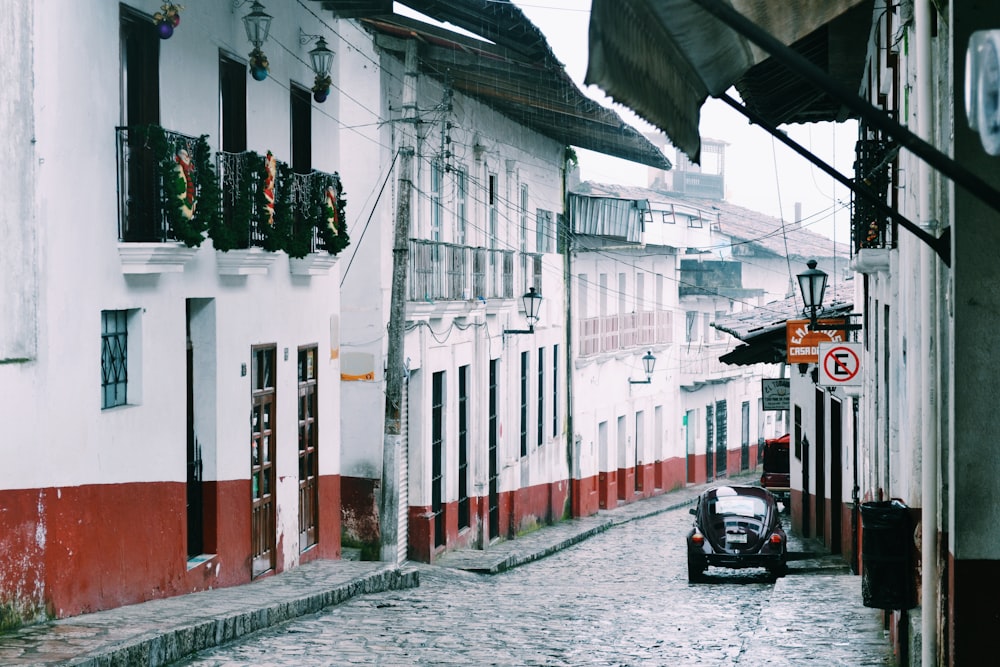 black car between buildings at concrete highway