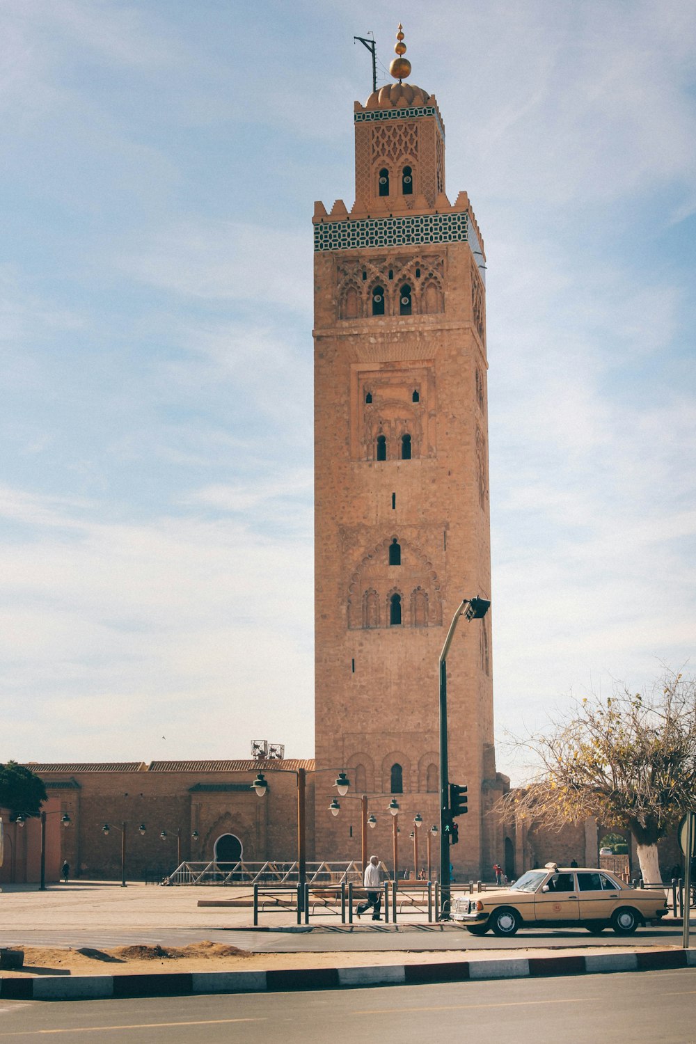 sedan parked at road beside tower