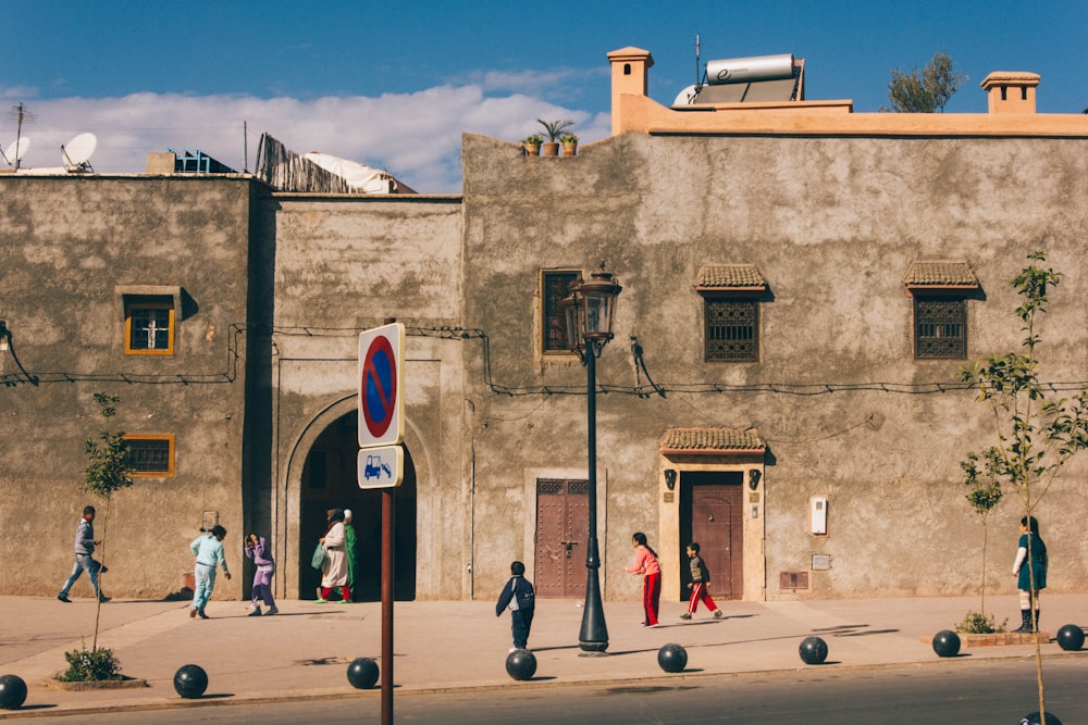 people walking beside concrete building at daytime