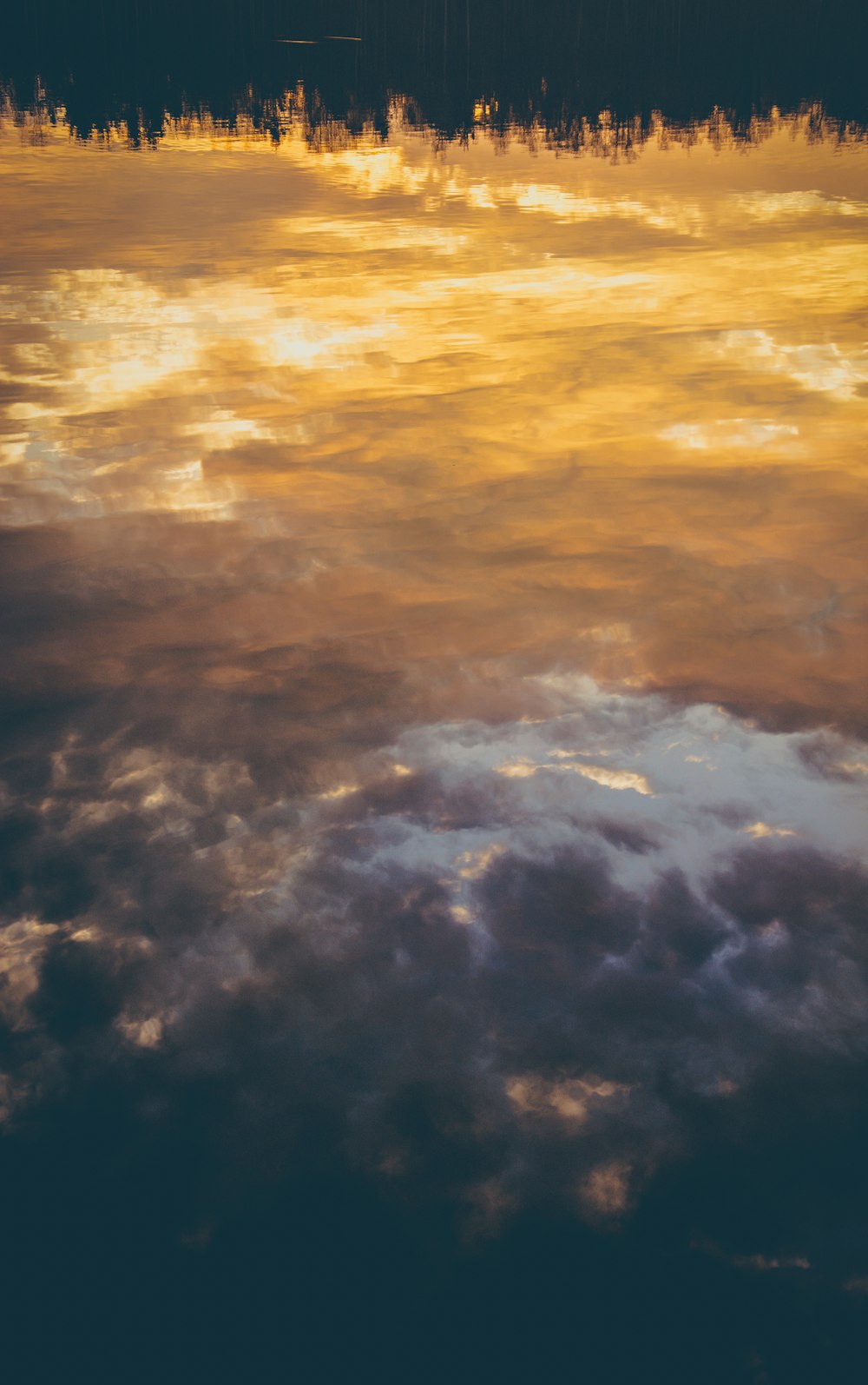 silhouette of city buildings under dramatic clouds during sunset