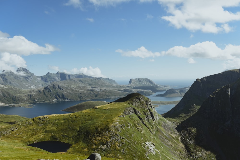 Des montagnes vertes entourées d’eau sous le jour