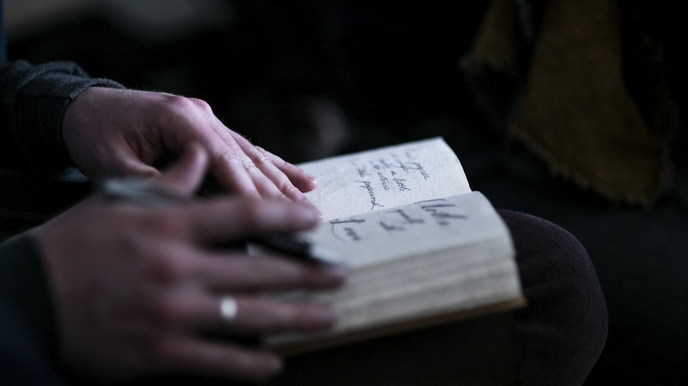 person holding white book