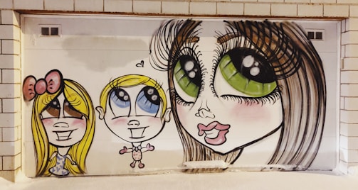 The image features a vibrant mural depicting three stylized cartoon characters with exaggerated features such as large eyes and big smiles. The characters are painted on a white tiled wall, adding a playful and whimsical vibe.