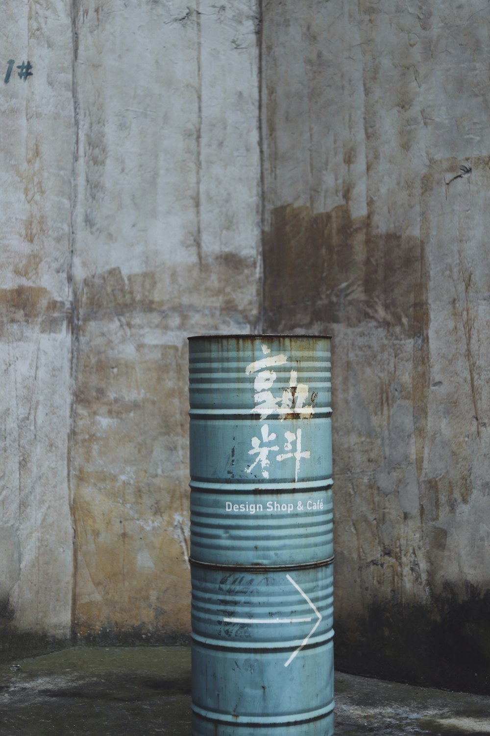 two blue barrel cans by the wall